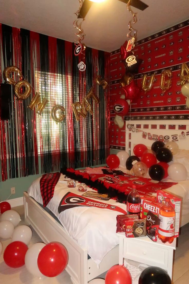 Georgia Bulldogs bed party with GO DAWGS balloon letters, red and black streamers covering walls, and extensive UGA merchandise